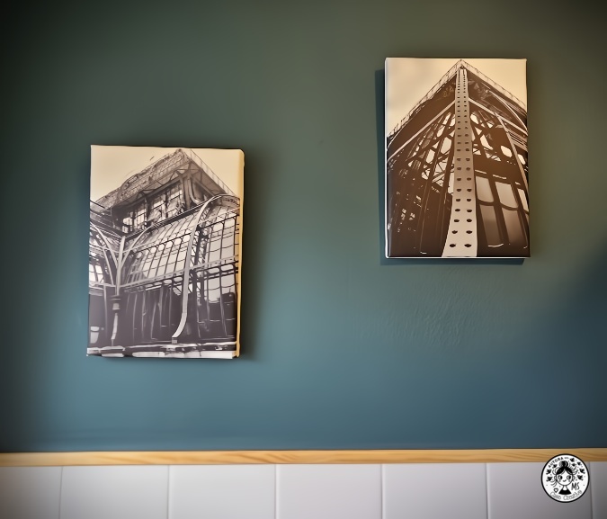 Cuadros en blanco y negro sobre pared verde oscuro en un baño renovado.