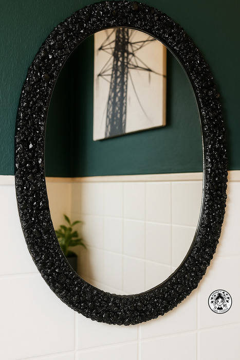 Espejo ovalado con marco DIY negro brillante decorando baño pequeño renovado