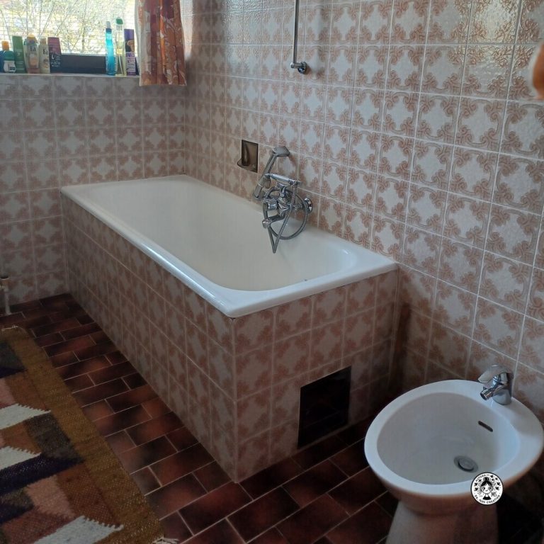 Imagen de la bañera original con azulejos antiguos antes de la reforma del baño